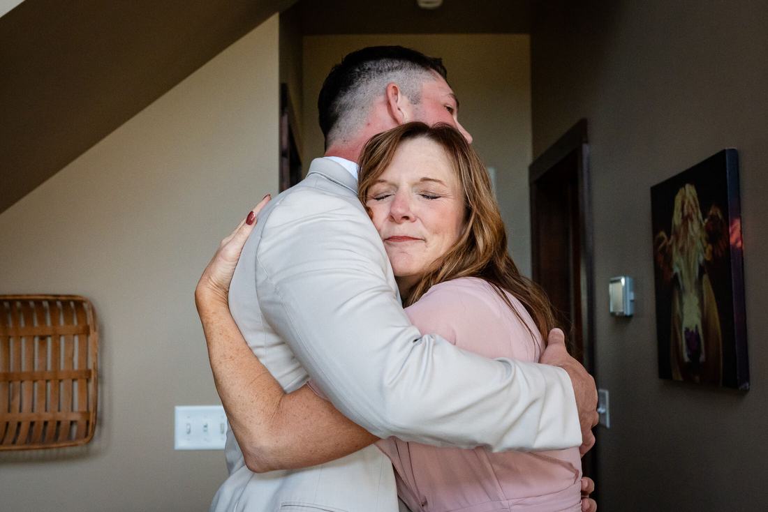 Emotional embrace between groom and mother